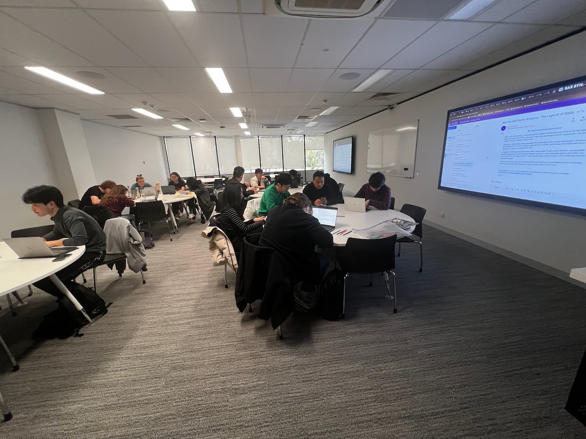 Students at tables working collaboratively during a tutorial.