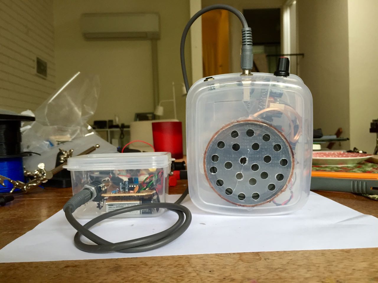 A synth and mini amp in tupperware enclosures.